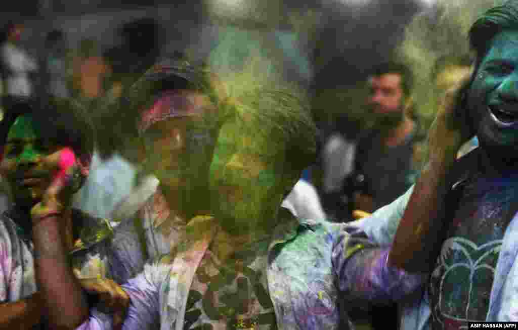 Pakistani Hindu men play with colored powder as they celebrate the Holi festival in Karachi on March 20.&nbsp;(AFP/Asif Hassan)
