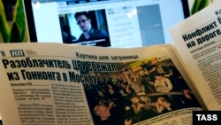 A laptop computer and a newspaper show reports about the arrival of former CIA contractor Edward Snowden to Russia, at Moscow's Sheremetyevo Airport, in June 2013.