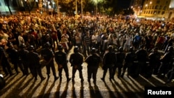 Участники антиправительственной демонстрации в Бразилии стоят напротив полицейских. Рио-де-Жанейро, 24 июня 2013 года.