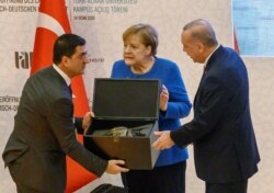Ангела Меркель (в центре) в Турции встречалась с Реджепом Эрдоганом (справа) совсем недавно, в конце января. Но с тех пор многое изменилось