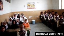Afghan schoolchildren attend a class at the Shahid Nasseri refugee camp in the village of Taraz Nahid near the city of Saveh, some 130 kilometers southwest of the Iranian capital, Tehran, in February 2015.