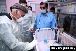 Afghan President Ashraf Ghani visits some of the injured and motherless newborns from the May 12 attack.