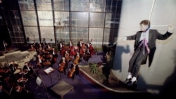 French conductor Hugues Reiner hangs from the roof of the shell-scarred Holiday Inn during a Sarajevo philharmonic concert in 1993.