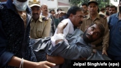 FILE: People shift a victim who was injured in cross border firing between the Indian and Pakistani forces in Jammu, the winter capital of Indian-adminstered Kashmir.