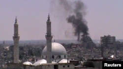 Smoke rises from the Juret al-Shayah district in the Syrian city of Homs on July 11.