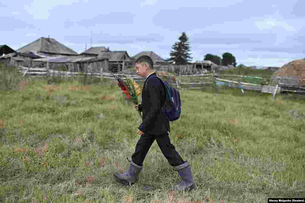 Ramil Kuchukov walks out of Sibilyakovo toward school in a larger nearby village. His journey will involve a 30-minute boat ride, followed by 20 minutes on a bus.