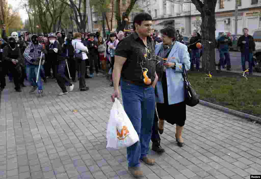 Masked pro-Russia protesters pelt supporters of Ukrainian presidential candidate Yulia Tymoshenko with eggs outside a regional government building in Donetsk. (Reuters/Marko Djurica)