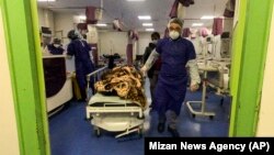 A medic moves a patient in a ward dedicated to people infected with the coronavirus at Forqani Hospital in Qom, the most affected region in Iran, on February 26.