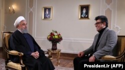 Iranian President Hassan Rouhani (L) gives a televised interview in Tehran, January 22, 2018