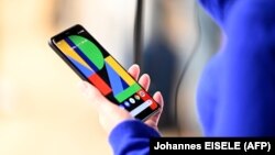 A woman holds tthe Google Pixel 4 phone during a Google product launch event called 'Made by Google 19' in New York City on October 15, 2019. - Google unveiled its newest Pixel handsets, aiming to boost its smartphone market share with features including 