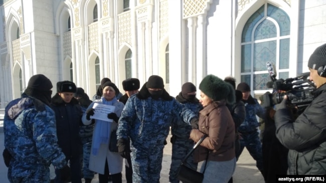 Полицейские задерживают гражданскую активистку Санавар Закирову, которая просила подаяние ради погашения иска членов партии «Нур Отан». Нур-Султан, 22 ноября 2019 года.