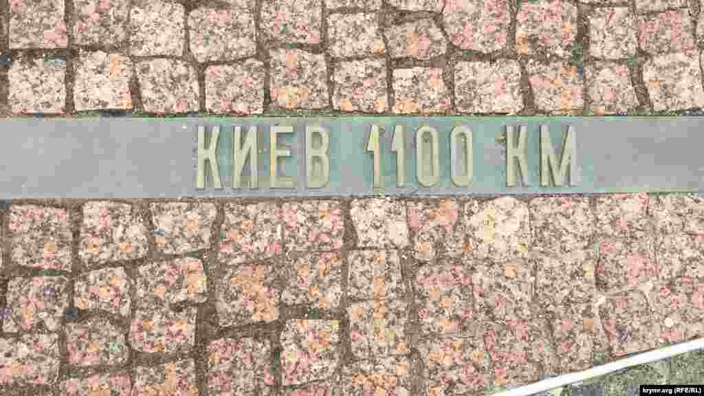 Від скульптури розходяться плиткові «промені», на яких вказано відстань від Керчі до інших міст України