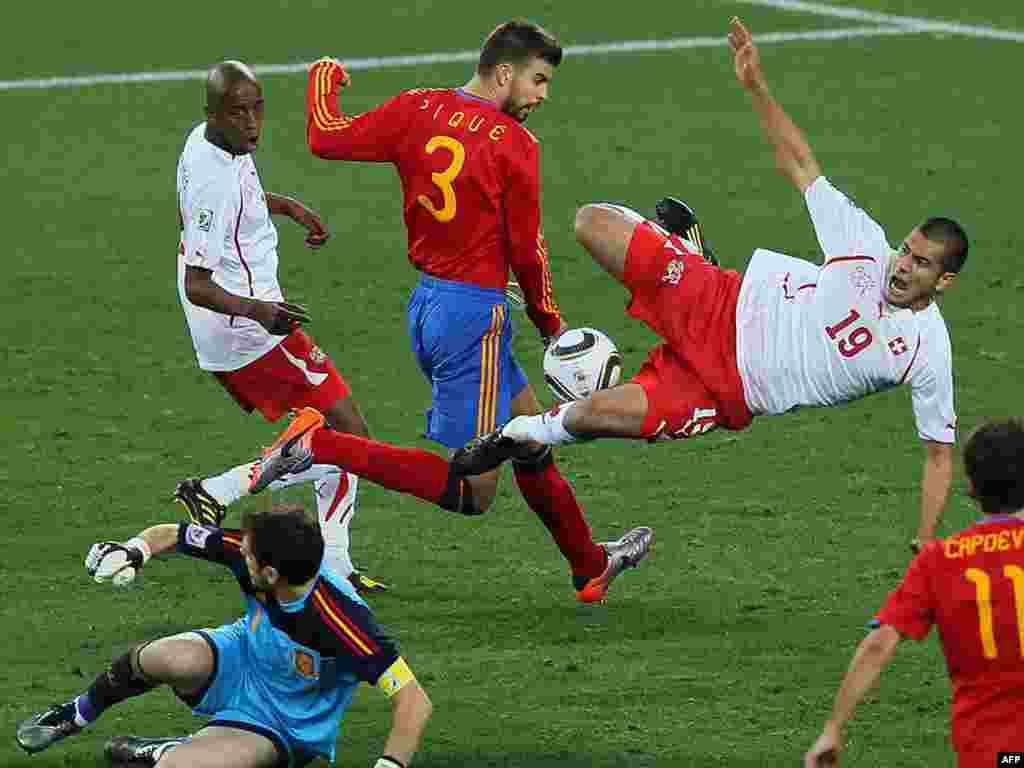 South Africa -- Switzerland's midfielder Gelson Fernandes (L) and Eren Derdiyok (R) as he is challenged by Spain's defender Gerard Pique (C) behind goalkeeper Iker Casillas (C-bottom) moments before Switzerland scored, Durban, 16Jun2010 - SOUTH AFRICA, Durban : Switzerland's midfielder Gelson Fernandes (L) looks at teammate Eren Derdiyok (R) as he is challenged by Spain's defender Gerard Pique (C) behind goalkeeper Iker Casillas (C-bottom) moments before Switzerland scored during their 2010 World Cup group H first round football match on June 16, 2010 at Moses Mabhida stadium in Durban. Switzerland won 1-0. NO PUSH TO MOBILE / MOBILE USE SOLELY WITHIN EDITORIAL ARTICLE - AFP PHOTO / KARIM JAAFAR 