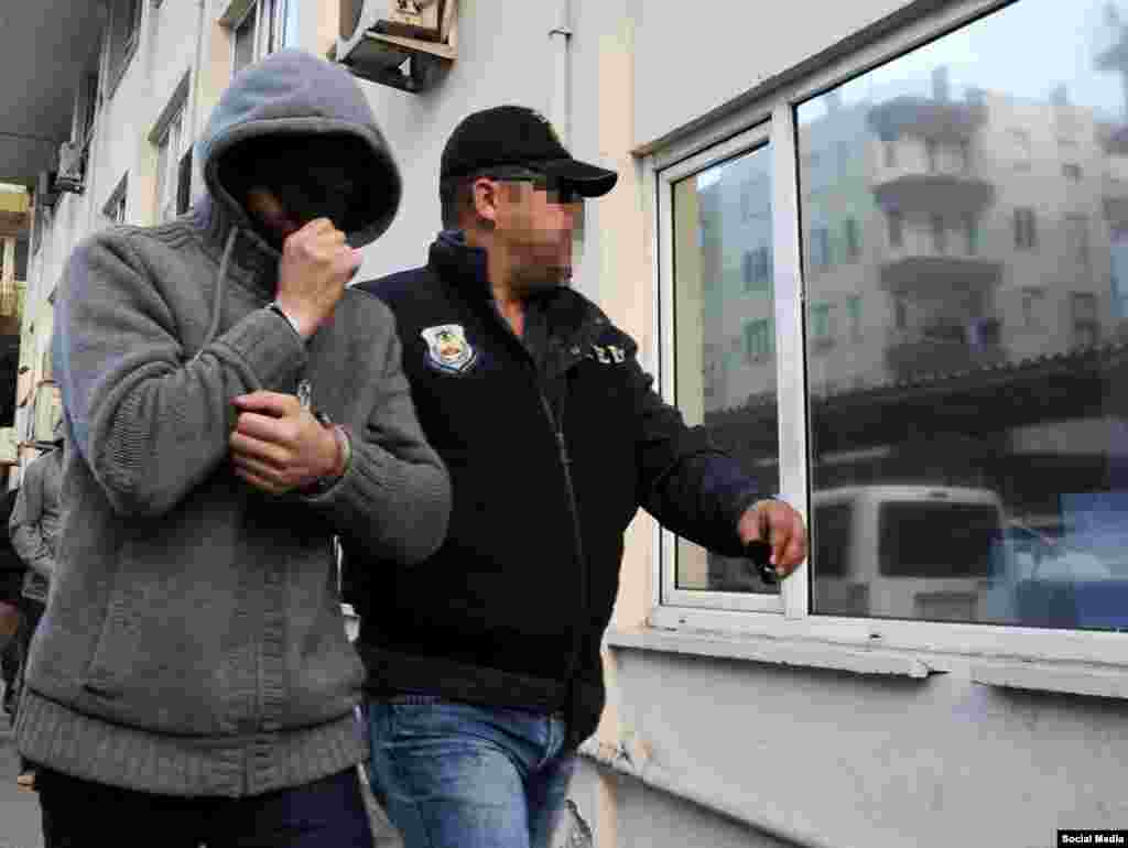 Турецкий полицейский сопровождает задержанного по подозрению в причастности к террористической деятельности гражданина России. Анталья, 13 января