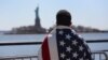 Участник марша иммигрантов смотрит на Статую Свободы. Нью-Йорк, 6 апреля 2013 года. Иллюстративное фото.