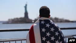 An immigrant looks toward New York's Statue of Liberty during a march for immigration reform in April.