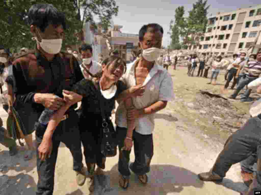 China - The mother (C) of two high school girls, Qiqi and Jiajia, who died when the Juyuan Middle School was destroyed in the devastating earthquake, Juyuan, 19May2008