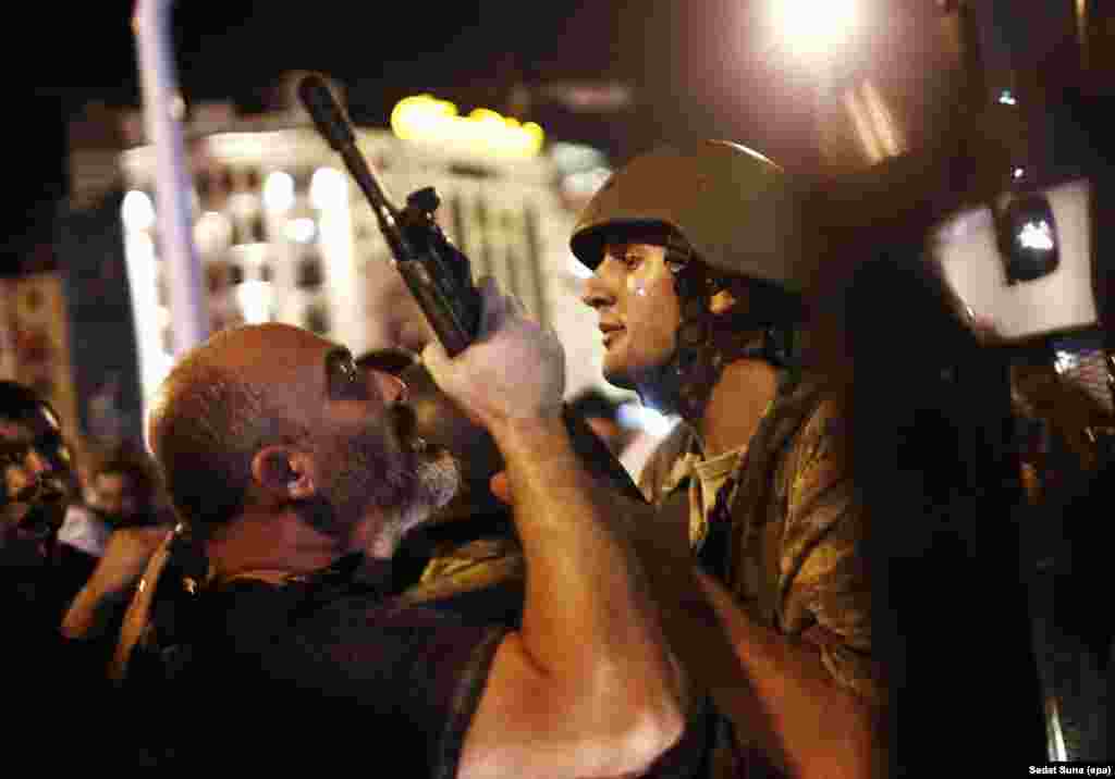 &quot;Kur arrita në Sheshin Taksim, një nga ushtarët pyeti, &#39;Çfarë ka ndodhur, pse je këtu?&#39; Unë i thash: &#39;Do të jetë rrezik për ty, duhet të shkosh në shtëpi.&#39; Kjo fotografi është e ushtarit të fundit në shesh që nuk u arrestua. &quot;Situata ishte shumë e tensionuar. Personi në anën e majtë është një polic i njësitit special duke thënë &#39;Duhet ta ndalni këtë. Ma jep armën.&#39; Ushtari i thoshte: &#39;Nuk ta dhe armën. Kam marrë urdhëra, nëse tenton ta marrësh nga unë, do të filloj të gjuaj.&#39; Ky diskutim zgjati ndoshta një minut dhe pastaj polici e arrestoi ushtarin... Shumë ushtarë menduan se ishin në ushtrimet që i ka ushtria. Ndoshta tani ata janë ende në burg. Është mjaft e trishtë. Sedat Suna, fotograf i EPA, duke spjeguar tentim grusht shtetin në Stamboll.