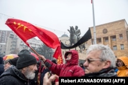 Një protestues, para Kuvendit të Maqedonisë, valëvitë flamurin e vjetër të Maqedonisë, teksa proteston kundër ndryshimit të emrit të vendit. Shkup, 9 janar, 2019.