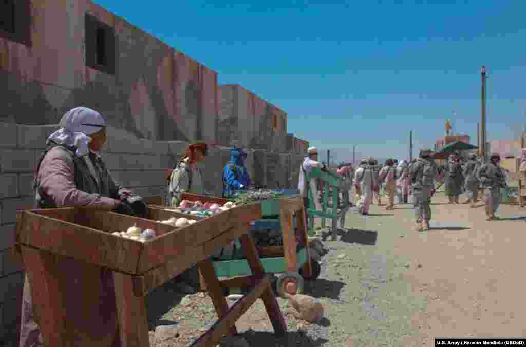 U.S. soldiers from Fort Irwin pose as Afghan street vendors in Medina Jabal, one of two mock towns constructed at the training center to simulate urban combat environments.&nbsp; 