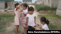 Дочери Айгуль Кенжехан играют с соседской девочкой. Алматинская область, 7 августа 2016 года.