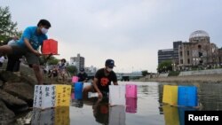 Ljudi puštaju papirnate lampione u rijeku Motojacu u znak sjećanja na žrtve Hirošime, 6. avgust 2020. 