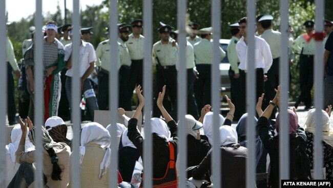 Policemen stand guard in front of women wearing white scarves trying to enter the stadium to watch the Asian qualifying match against Bahrain for World Cup 2006, 08 June 2005.