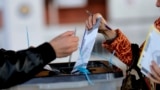 A voter casts her ballot at a voting center in Pristina. (file photo)