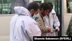 تصویر آرشیف: دو کارمند صحی در هنگام صحبت و بررسی داشته های یک فرد معتاد در کابل 