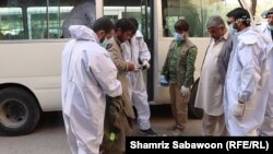 کارمند صحی یکی از مراکز تداوی معتادان در کابل وسایل یک معتاد را بررسی می کنند