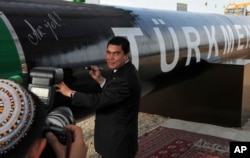 Former Turkmen President Gurbanguly Berdymukhammedov signs a new gas pipeline during an opening ceremony in 2010.