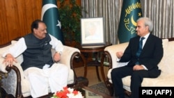 Pakistani President Mamnoon Hussain (L) listens to caretaker Prime Minister Nasir-ul Mulk after an oath-taking ceremony at the President House in Islamabad on June 1.