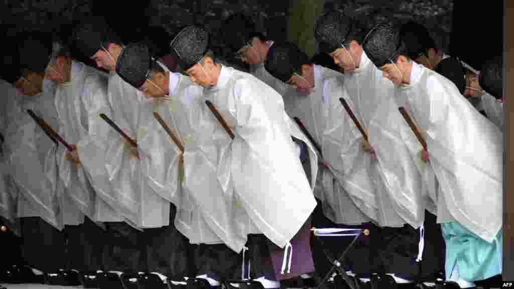Shinto priests bow during a ritual end-of-the-year purification ceremony to prepare for New Year&#39;s Day at Meiji Shrine in Tokyo. Millions of Japanese people will visit shrines and temples across the country to celebrate New Year&#39;s Day, one of the most important holiday periods of the year. (AFP/Yoshikazu Tsuno)
