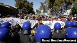Стоящие на пути демонстрантов работники сил безопасности Алжира. 3 марта 2019 года.