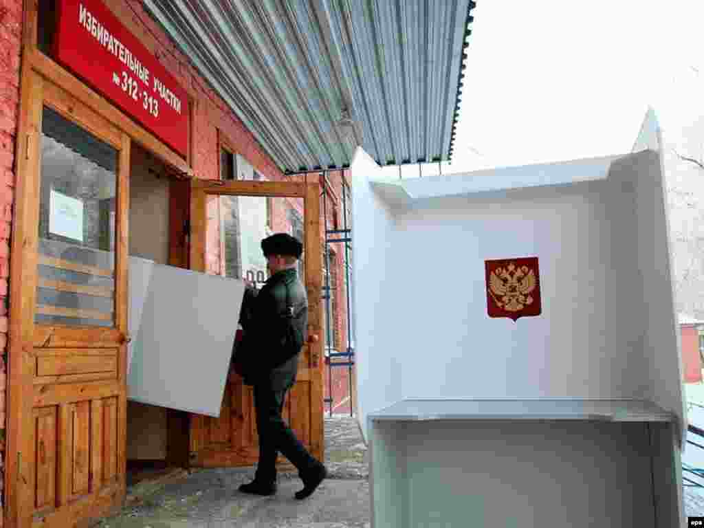 Russians went to the polls today across 11 timezones to vote for a new parliament. Members of the local election commission prepare the polling station in the western Siberian city of Kemerovo.