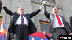  Бывший президент Левон Тер-Петросян (слева) и Никол Пашинян приветствуют сторонников на митинге в Ереване, 31 мая 2011 года.