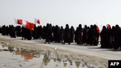 Шыіцкія жанчыны з нацыянальнымі сьцягамі на пахаваньні забітых дэманстрантаў 18 лютага 2011 г.