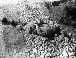 Тело одного из нескольких американских солдат, казненных после взятия в плен северокорейскими войсками к югу от Сеула в начале июля.