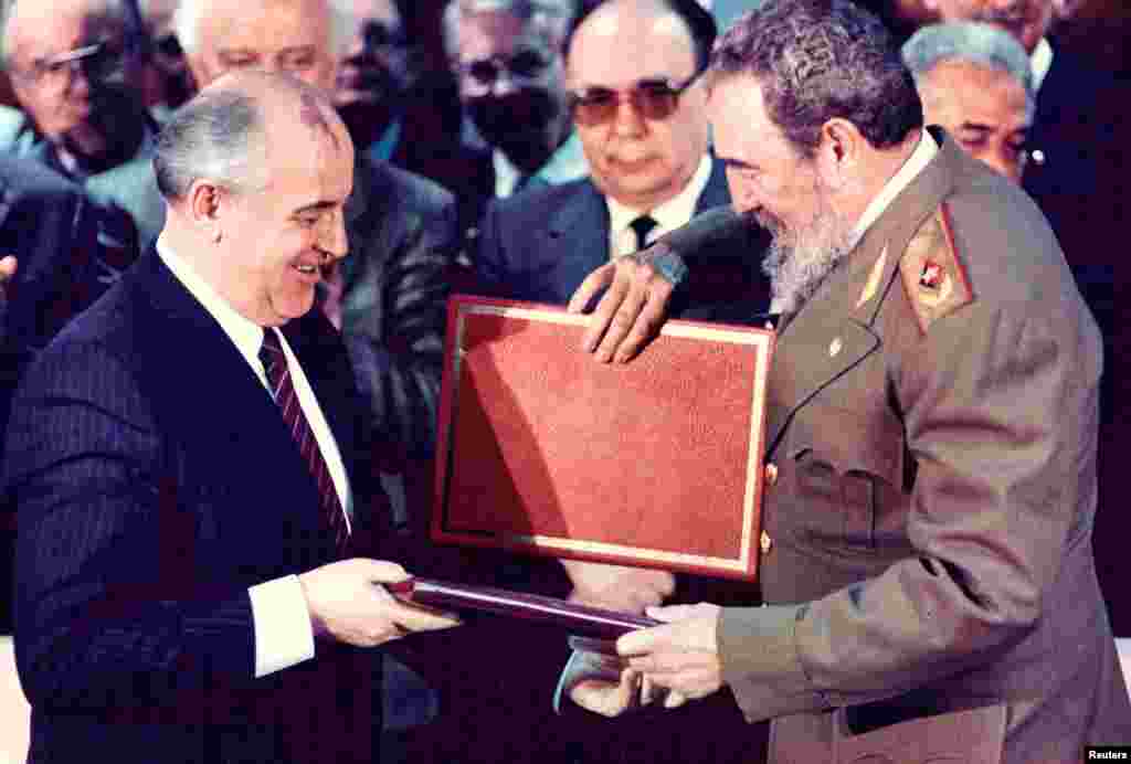 Castro (right) and then-Soviet leader Mikhail Gorbachev exchange documents during a treaty signing ceremony in Havana in 1989.&nbsp;