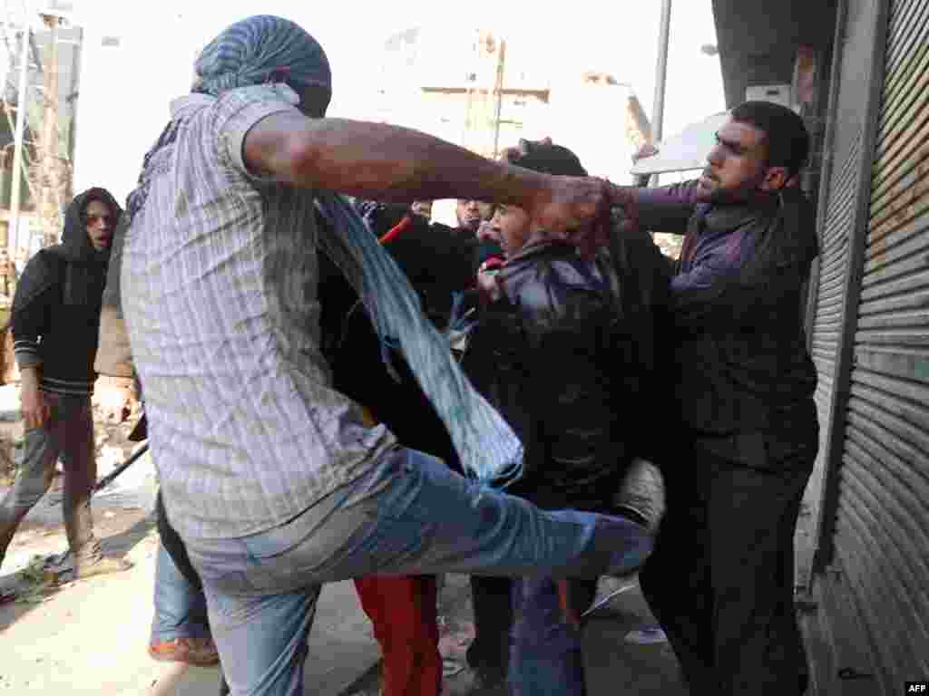 Antigovernment protesters beat and lead away a Mubarak supporter.