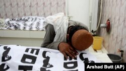 A man mourns over a dead body of his family member who was killed in a bomb attack on an election rally in the southwestern Pakistan province of Balochistan on July 13.