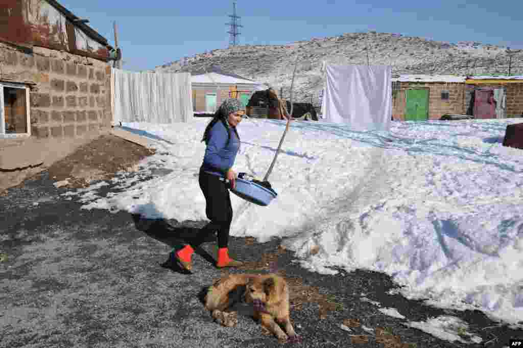 Armenia -- Liana Amarian goes to hang up washing outside her family's stone home, in the Armenian village of Zovuny, 01May2013