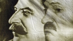 A poster with portraits of Josef Stalin (left) and Alyaksandr Lukashenka seen at a protest rally in May.