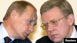 President Vladimir Putin (left) and Finance Minister Aleksei Kudrin speak to each other during a meeting of economy ministers in Moscow in March 2004.