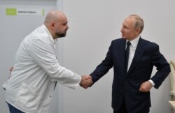 Володимир Путін тисне руку головному лікарю інфекційної лікарні в Москві Денису Проценку