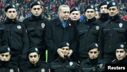 Турэцкі прэзыдэнт Рэджэп Таіп Эрдаган пазіруе разам з паліцыянтамі перад пачаткам футбольнага матчу, сьнежань 2016-га