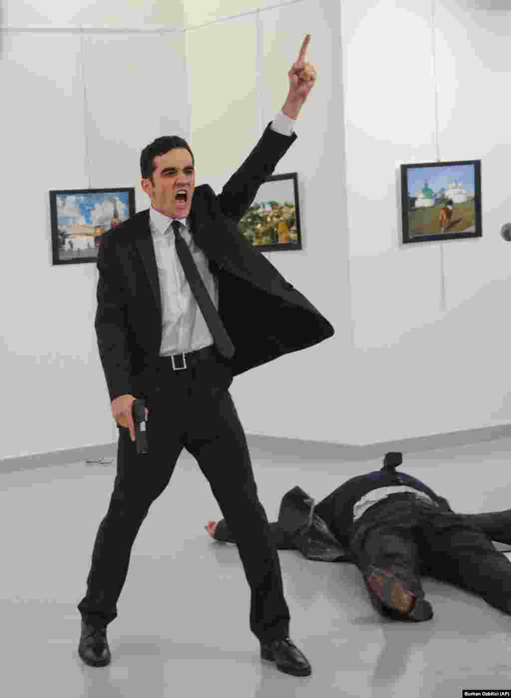 An off-duty Turkish police officer, Mevlut Mert Altintas, shouts "Don't forget Aleppo!" moments after he shot and killed the Russian ambassador to Turkey, Andrei Karlov, at a photo exhibition in Ankara on December 19. Altintas was later killed by police in a shoot-out. (AP/Burhan Ozbilici)