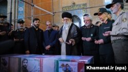 Supreme Leader Ayatollah Ali Khamenei prays above the casket of Mohsen Hojaji, a young member of Iran's Revolutionary Guards who was beheaded in Syria by IS group fighters, during his funeral in Tehran in September 2017.