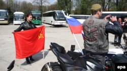 Расейскія байкеры пазуюць з расейскім ды савецкім сьцягамі ў Асьвенцыме.