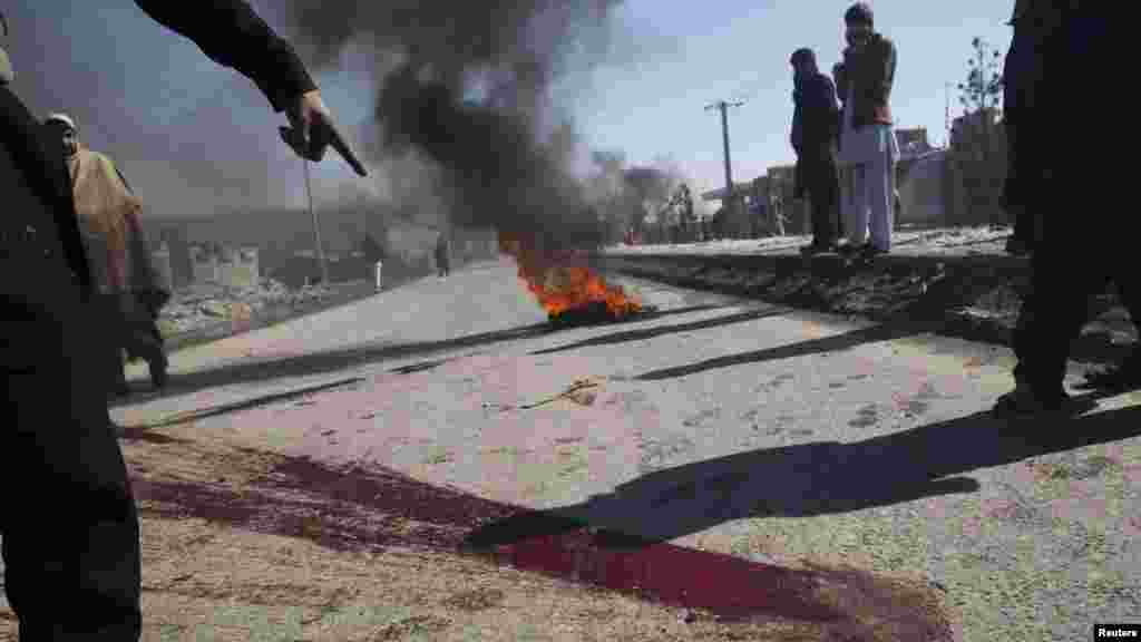 A man points to blood on a street during a protest near a U.S. military facility in Kabul on February 22.